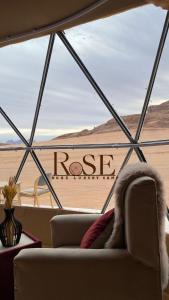 a view of the desert from a window with a couch at Wadi Rum Rose camp in Wadi Rum