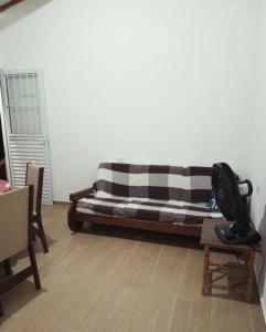 a couch in a living room with a wooden floor at Chalé Ilhabela in Ilhabela