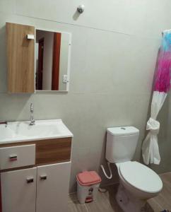 y baño con aseo, lavabo y espejo. en Chalé Ilhabela, en Ilhabela