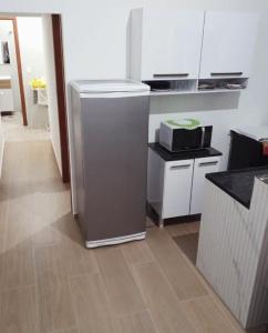 a kitchen with a refrigerator and a counter top at Chalé Ilhabela in Ilhabela