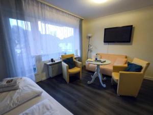 a hotel room with a bed and a table and chairs at Hotel Sonnenhof Garni in Bad Herrenalb
