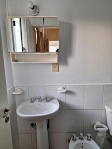 a bathroom with a sink and a mirror and a toilet at Altos Mendoza Calle Entre Ríos in Mendoza