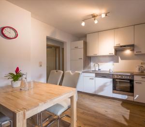 eine Küche und ein Esszimmer mit einem Holztisch und Stühlen in der Unterkunft Appartement Nani in Söll