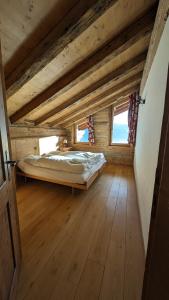 um quarto com uma cama num quarto com pisos em madeira em Alpenpanorama Ovronnaz em Ovronnaz