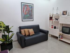 un sofá de cuero negro en una sala de estar con TV en Heart Of Copacabana Studio Beach & Metro, en Río de Janeiro