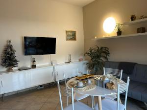 ein Wohnzimmer mit einem Tisch und einem TV in der Unterkunft La Corte di Silvia Malpensa in Cardano al Campo
