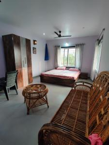 a bedroom with a bed and tables and chairs at Barn field Villa and Farmstay in Baya