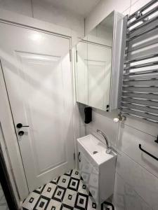 een witte badkamer met een wastafel en een spiegel bij Comfortable and luxurious flat 4 in Istanbul