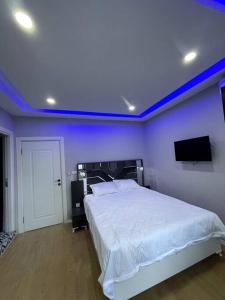 een slaapkamer met een wit bed en een blauw plafond bij Comfortable and luxurious flat 4 in Istanbul
