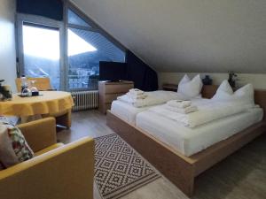 a hotel room with two beds and a large window at Hotel Sonnenhof Garni in Bad Herrenalb