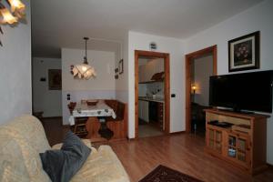 sala de estar con sofá y TV de pantalla plana en Residence Valfassa, en Canazei