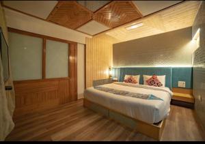 een slaapkamer met een groot bed in een kamer bij Aman The Lake Side Hotel in Nainital