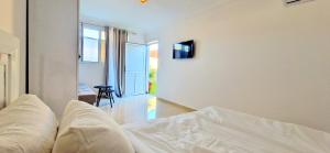 a white bedroom with a bed and a window at Beach Appartment close to Marina 105 sqm in Agadir