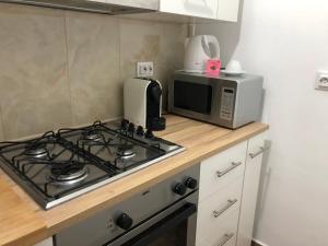 a kitchen with a stove top and a microwave at Orizont-Livezeni in Livezeni