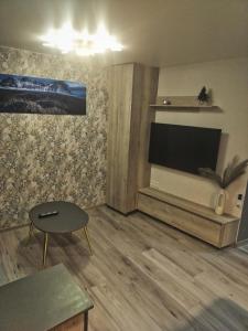 een woonkamer met een flatscreen-tv aan de muur bij Laivų gatvės apartamentai in Telšiai
