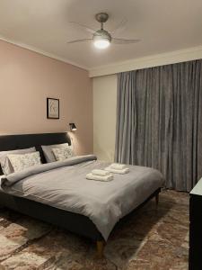 een slaapkamer met een bed met twee handdoeken erop bij Serene Apartment with Breathtaking Sea View in Thessaloniki