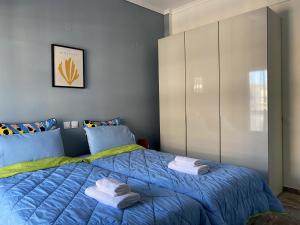 een slaapkamer met een blauw bed met handdoeken erop bij Serene Apartment with Breathtaking Sea View in Thessaloniki