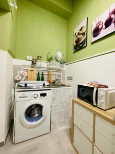 a laundry room with a washing machine and a microwave at A Casa di Clu - your private SPA in Palermo