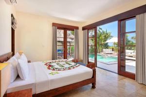 a bedroom with a bed and a view of a pool at Karma Kandara in Uluwatu