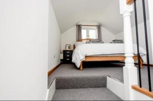 a bedroom with a bed and a window at Woodman's Cottage in Temple Ewell