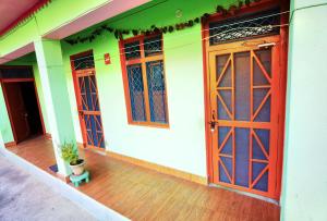 Ukhimath的住宿－Holiday Home Chopta Tungnath，前方有红门和盆栽的房屋