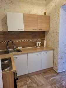 una pequeña cocina con armarios blancos y fregadero en Angel, en Altemburgo