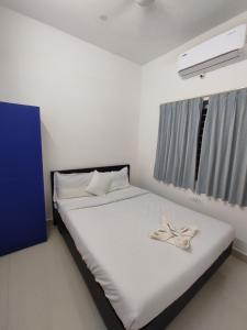 a bedroom with a white bed with a towel on it at Zylo Indiranagar in Bangalore
