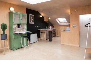 uma cozinha com um velho armário verde e um balcão em Stunning studio loft in Brixton, London em Londres