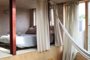 um quarto com uma cama e uma rede de descanso num quarto em Stunning studio loft in Brixton, London em Londres