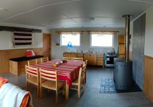 ein Esszimmer mit einem Tisch und einer Küche in der Unterkunft CABAÑA ESTANCIA LAZO in Torres del Paine