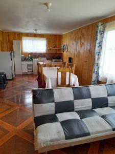 sala de estar con sofá y cocina en Cabañas encanto de Chovellen, en Pelluhue