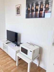 a living room with a microwave and a tv at Ferienwohnungen in Köln2201 in Cologne