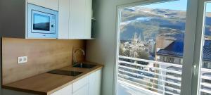 d'une cuisine avec évier et d'une fenêtre avec vue. dans l'établissement Apartamento en Plaza Central con garaje Gratis, à Sierra Nevada