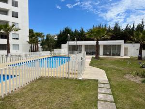 una valla blanca alrededor de una piscina frente a un edificio en Departamento en La Serena en La Serena