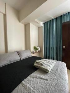sypialnia z łóżkiem i dużym oknem w obiekcie The Beach Suite at The Mactan Newtown w mieście Lapu Lapu City