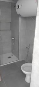 La salle de bains blanche est pourvue d'une douche et de toilettes. dans l'établissement Apartamento en Plaza Central con garaje Gratis, à Sierra Nevada