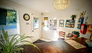 a dining room with a table and a clock on the wall at Motel Bonsoir in Joliette