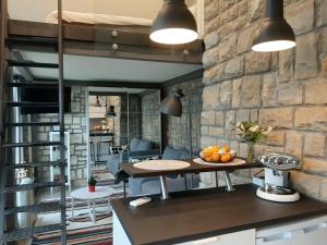 a kitchen with a table and a stone wall at Studio Solare in Portorož +42 photos