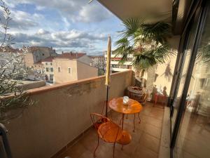 een balkon met een tafel en stoelen bij L’appartement du bonheur in Issoire