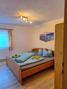 sypialnia z dużym drewnianym łóżkiem z niebieskimi poduszkami w obiekcie Ferienhof Bichlhof w mieście Arzl im Pitztal