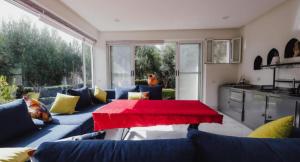 een woonkamer met een blauwe bank en een rode tafel bij Bungalow vert 1 in Essaouira