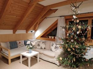 a living room with a christmas tree and a couch at Srub Javorná - apartmány Šumava in Javorná