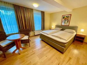 a bedroom with a bed and a table and chairs at Hotel Restaurant Steinkrug in Wennigsen