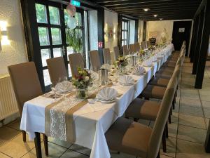 ヴェニッヒセンにあるHotel Restaurant Steinkrugの白いテーブルと椅子と花