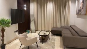 sala de estar con sofá, sillas y TV en شقة فخمة 3 غرف نوم في حي الملقا قريبه من البوليفارد The Nook, luxury 3BD Flat in malqa district near BLVD, en Riad