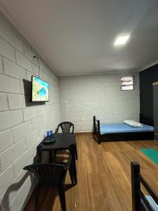 Zimmer mit einem Bett, einem Tisch und einem Sofa in der Unterkunft Reserva Athenas - Clube de campo in Jacareí