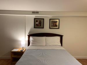 sypialnia z łóżkiem i 2 zdjęciami na ścianie w obiekcie Brighton Guesthouse (Walk to Metro) w mieście Seattle