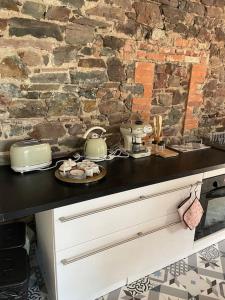 a kitchen with a counter with a stone wall at La Maison Cahour in Redon