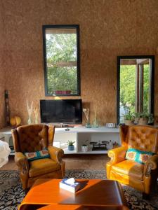 a living room with two chairs and a flat screen tv at La Maison Cahour in Redon +19 photos