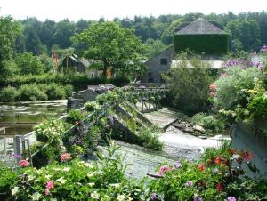 a garden with a bunch of flowers and a building at La Maison Cahour in Redon